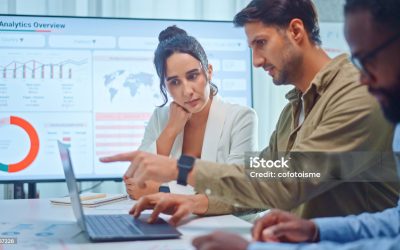 A team of multiethnic developers is meeting to discuss the data analytics of marketing.